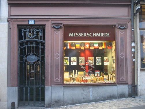 Basel Spalenberg 33, das
                        Schaufenster der Messerschmiede mit senkrechten
                        Sonnenhieroglyphen in Rhombusform, mit kleinen
                        Bndnisgirlanden und Templer-Pfeilen
                        (Templer-V)