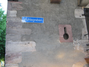 Basel, Sankt-Alban-Rheinweg,
                                Stadtmauer, Strassenschild
                                "Mhlegraben" am Glockenhaus,
                                und eine Schiessscharte
