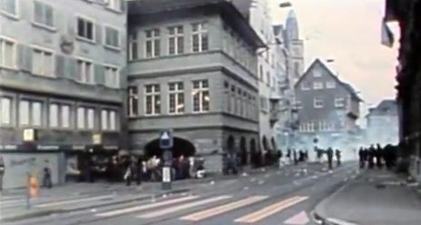 People near the
                            town hall taking their flight from the bully
                            police (Nazis in blue) from tear gas and
                            rubber bullets fleeing to Market Lane
                            (Marktgasse), June 18, 1980