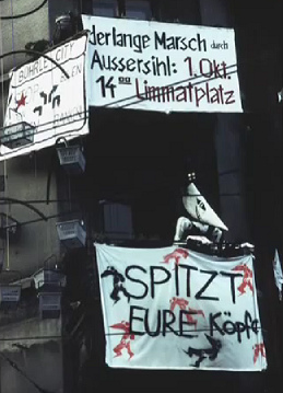 Squatting of Baden Street N 2, banner
                          announcing a demonstration "Long March
                          passing Aussersihl District", October
                          1983