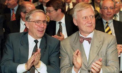 Christoph Blocher (left)
                    with Martin Ebner (right) at a meeting in 1999
                    clasping