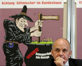 Mr.
                            Ueli Maurer presenting the bowl with a
                            poisoned liquid warning from Schengen
                            agreement in October 2004