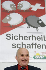 Ueli Maurer with
                          racist SVP poster with the black sheep in
                          summer 2007