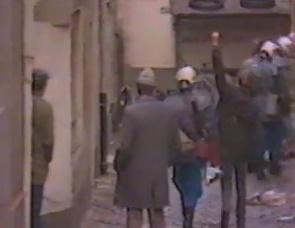 A sympathizer is detained rising
                            her fist against the property sharks, 1984