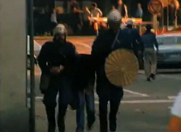 Zwei Zrcher
                          Schlgerpolizisten (Nazis in Blau) drehen
                          einer unbewaffneten Passantin an der Kreuzung
                          Zollstrasse / Radgasse die Arme um, Abend des
                          4.9.1980, 02