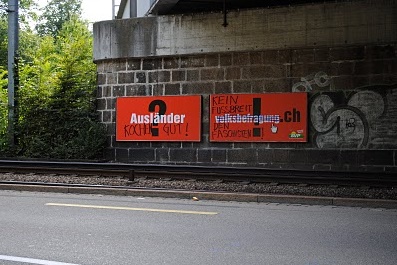 Plakate in den Nazi-Farben
                                schwarz-rot-weiss mit der Behauptung, es
                                gbe eine "Volksbefragung"
                                ber Auslnder, mit Graffiti, 2010