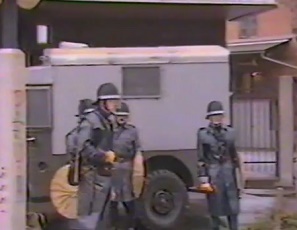 Ein Schlgerpolizist
                          (Marsmensch) der Stadt Zrich mit einem
                          Transportwagen fr Verhaftungen